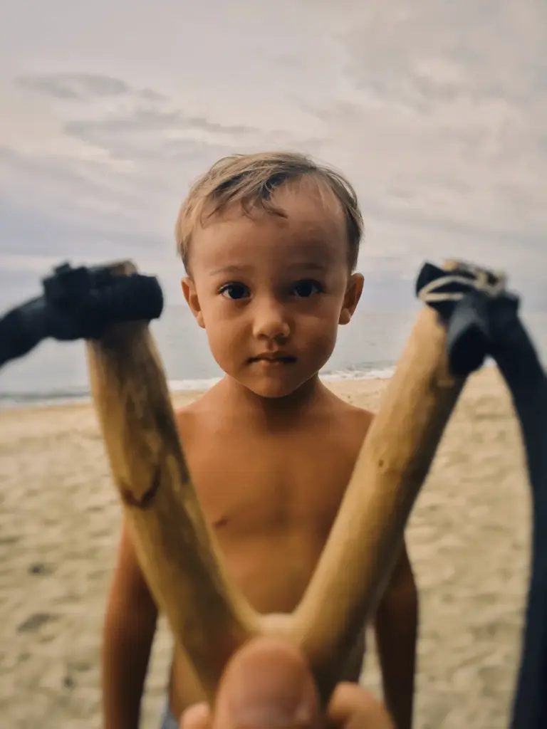Kid staring into straight into the camera at the beach