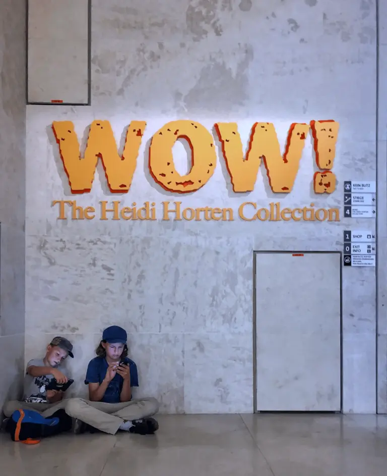 Two children sit on the floor playing games at the Heidi Horten Collection exhibition.
